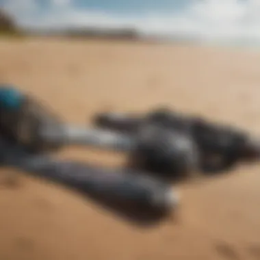 A close-up of kitesurfing gear laid out on the sandy beach