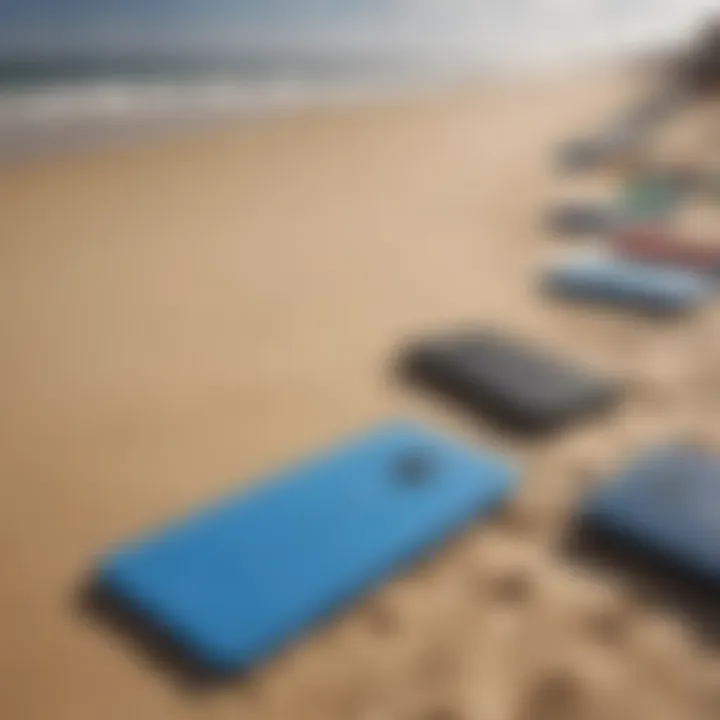 A close-up view of various types of boogie boards displayed on a sandy beach.