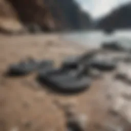 Vans black flip flops on a rocky beach