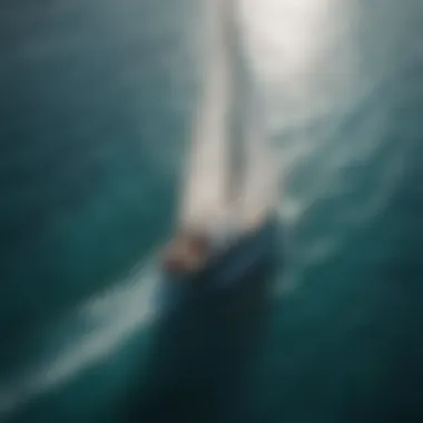 An aerial view of a sailing boat navigating through crystal clear waters